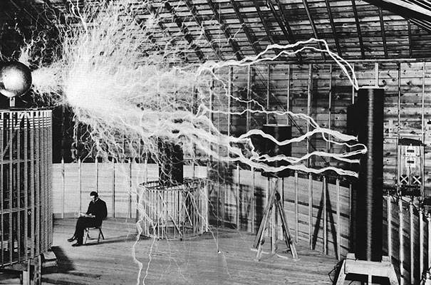 12.) Nikola Tesla sitting in his laboratory with his "Magnifying Transmitter."